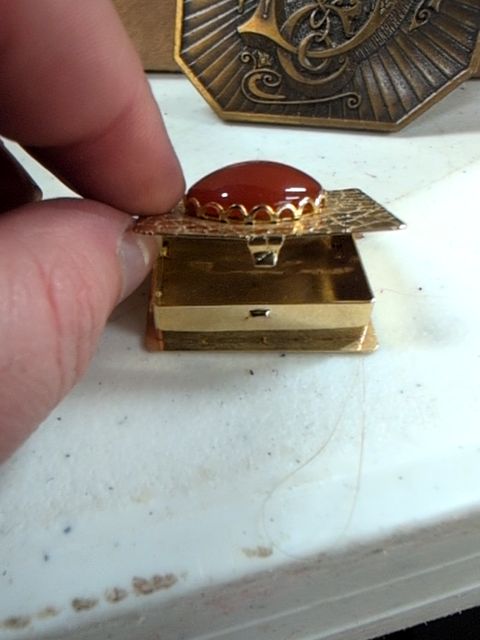 Locket book for necklace with orange gem on top