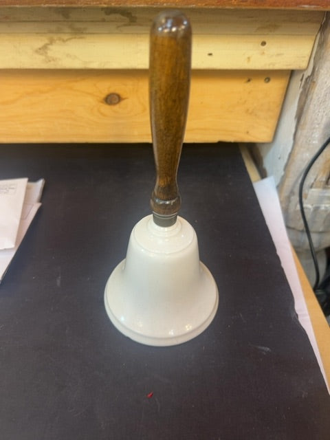 White bell with wooden handle